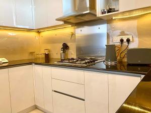 una cucina con armadi bianchi e piano cottura di Apartment Universal a Galle