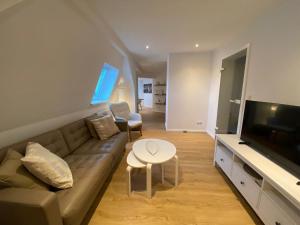 a living room with a couch and a flat screen tv at Ferienwohnung Luxusblick in Bad Harzburg