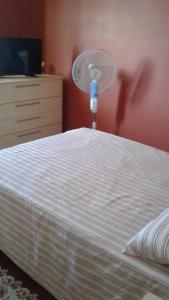 1 dormitorio con 1 cama y ventilador en la pared en EJC en Flic-en-Flac