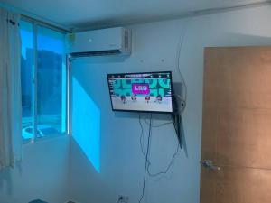 a tv hanging on a wall in a room at Apto nuevo, amoblado sector tranquilo, buen precio in Barranquilla