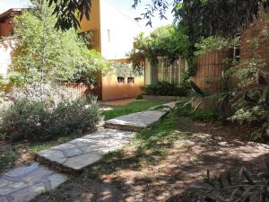 un jardín con un camino de piedra frente a un edificio en Tu casa en el centro en San Rafael