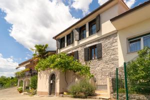 a villa with a stone house with a gate at Villa Salvia with pool in Ružići