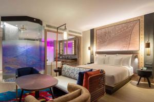 een hotelkamer met een bed, een tafel en een stoel bij Hotel Indigo Phuket Patong, an IHG Hotel in Patong Beach