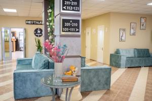 a lobby with blue couches and a table with flowers at Aktau Airport Hotel in Aktau