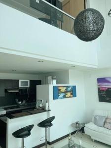 uma cozinha e uma sala de estar com bancos num quarto em Beautiful 1 Br Loft Apartment em Manizales