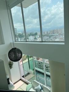 um quarto com uma grande janela com vista para a cidade em Beautiful 1 Br Loft Apartment em Manizales