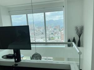 um monitor de computador sentado em frente a uma janela em Beautiful 1 Br Loft Apartment em Manizales