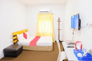 a bedroom with a bed and a desk with a computer at Citra Kadok Hotel & Banquet Hall in Kota Bharu