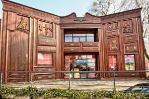 ein Holzgebäude mit einer großen Tür in der Unterkunft Teatr Baj Pomorski in Toruń