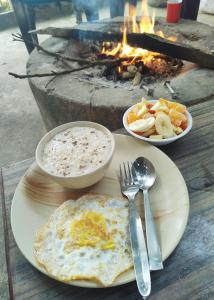 a plate with an egg and bowls of food and a grill at Bardia Eco Friendly Homestay in Bhurkīā