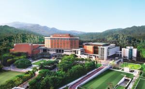 an aerial view of a building with mountains in the background at The-K Hotel Seoul in Seoul