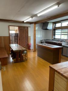 cocina grande con mesa y fregadero en 貸別荘バーンタイ戸狩 en Togari