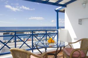 einen Balkon mit einem Tisch, Stühlen und Meerblick in der Unterkunft Harbour Lights in Puerto del Carmen