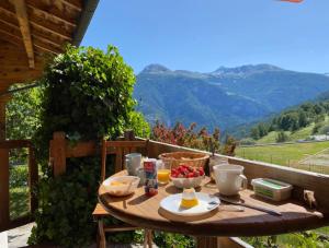 a table with a bowl of fruit on top of a balcony at Chalet Albarose - Vercorin in Vercorin