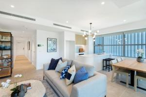 a living room and kitchen with a couch and a table at Escape to Serenity by Experience Jervis Bay in Huskisson