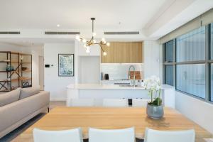 a living room and kitchen with a table and chairs at Escape to Serenity by Experience Jervis Bay in Huskisson