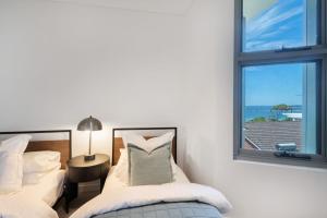 a bedroom with two beds and a window at Escape to Serenity by Experience Jervis Bay in Huskisson