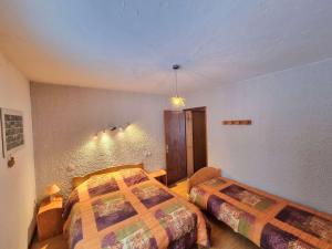 1 dormitorio con 2 camas y pared en Appartement Saint-Michel-de-Chaillol, 4 pièces, 9 personnes - FR-1-393-79, en Saint-Michel-de-Chaillol
