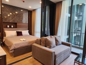 1 dormitorio con 1 cama, 1 sofá y 1 silla en A2 at Forest Khaoyai, en Ban Huai Sok Noi