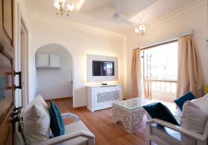 a living room with a couch and a tv at Lillywoods Highland Beach Resort- Candolim in Candolim