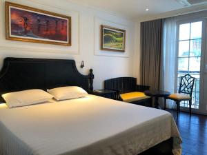 Un dormitorio con una gran cama blanca y una ventana en My Stay Hotel & Apartment, en Ho Chi Minh