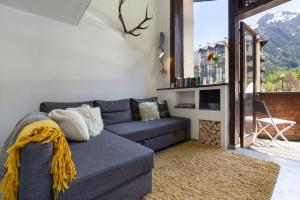 uma sala de estar com um sofá azul e uma lareira em Résidence Grand Roc - Ancolies 028 - Happy Rentals em Chamonix-Mont-Blanc