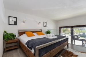 um quarto com uma cama grande e almofadas laranja em Résidence Grand Roc - Ancolies 028 - Happy Rentals em Chamonix-Mont-Blanc