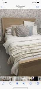 um quarto com uma grande cama branca com almofadas em Stay Salty em Culburra Beach