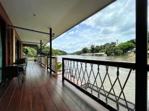 einen Balkon eines Hauses mit Flussblick in der Unterkunft Rimwang The River Life in Sai Yok