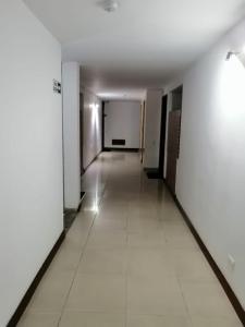 un pasillo vacío con paredes blancas y suelo de baldosa blanca en Paraíso del salitre, en Bogotá