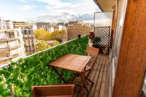 a wooden table and chairs sitting on a balcony at Studio with Balcony in Paris