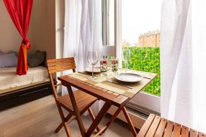 a wooden table with two chairs and a table with wine glasses at Studio with Balcony in Paris