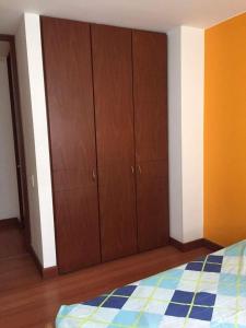 1 dormitorio con armarios de madera y 1 cama en Paraíso del salitre, en Bogotá