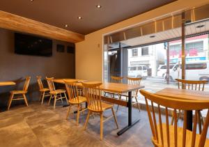 a restaurant with wooden tables and chairs and a window at APA Hotel Koriyama Ekimae in Koriyama