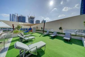 een groep stoelen en tafels op het dak van een gebouw bij Luxurious studio Hotel Amenities in Dubai