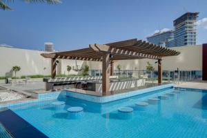 een zwembad met een prieel naast een zwembad bij Luxurious studio Hotel Amenities in Dubai