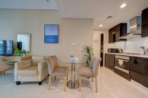 een keuken en een woonkamer met een tafel en stoelen bij Luxurious studio Hotel Amenities in Dubai