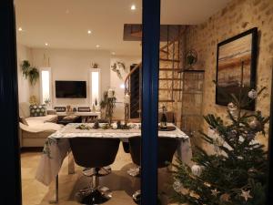 a living room with a table and a christmas tree at TUILERIE DE LA COTE 4* in Ouzouer-sur-Trézée