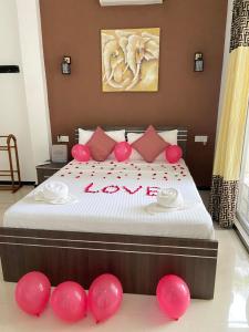 a bedroom with a bed with red balloons on it at White Villa Airport Transit Hotel in Katunayake