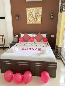 a bedroom with a bed with red balloons on it at White Villa Airport Transit Hotel in Katunayaka