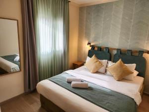 - une chambre avec un grand lit et un miroir dans l'établissement Kalia Kibbutz Hotel, à Kalia