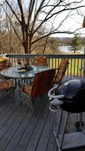 a table and chairs sitting on a deck with a table and chairs at Private Lakeview Cottage and 2 Farmhouse Apartments near Rt 80 easy to NYC in Blairstown