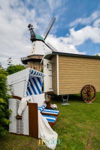 ein Haus mit einer Windmühle neben einer Gruppe von Stühlen in der Unterkunft Villa Hygge Kappeln - Ferienwohnungen in Kappeln