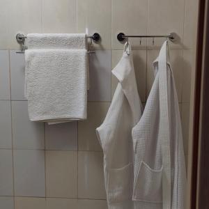 baño con toallas blancas colgadas en un estante en Гостиница ,,Меркурий и К,, en Astaná