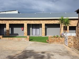 a brick house with a palm tree in front of it at A Step Ahead in Klerksdorp