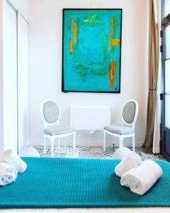 ナルボンヌにあるHotel Galla Placidiaのベッドルーム1室(椅子2脚、青いシーツ付きのベッド1台付)