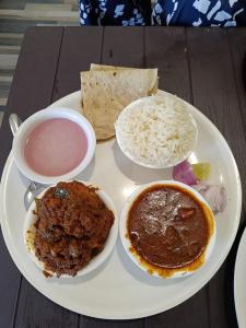 a plate of food with soup and rice on a table at Anant Resort Nagaon Beach Walking Distance 2min Alibaug in Alibaug