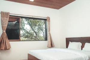 a bedroom with two beds and a window at Anant Resort Nagaon Beach Walking Distance 2min Alibaug in Alibaug