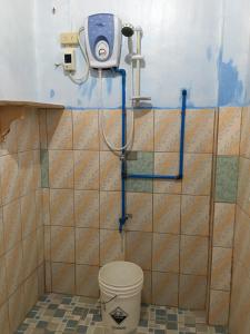 a bathroom with a toilet and a camera on the wall at Vilma's Homestay in Bontoc