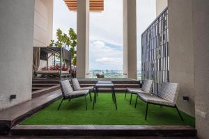 a balcony with four chairs and a table and green grass at HighPark Suites by Airhost in Petaling Jaya